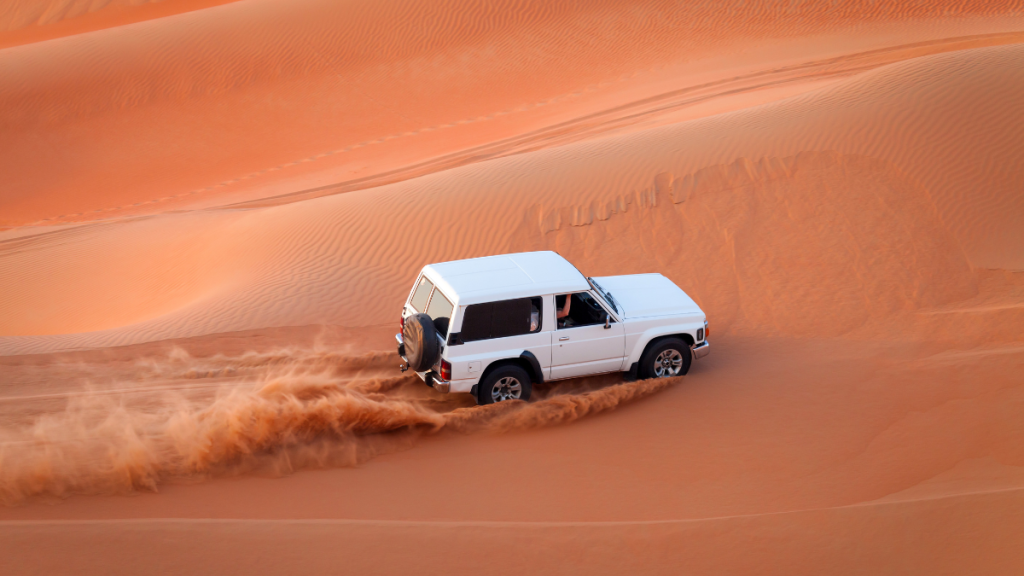 un fuoristrada bianco sulle dune del deserto in oman
