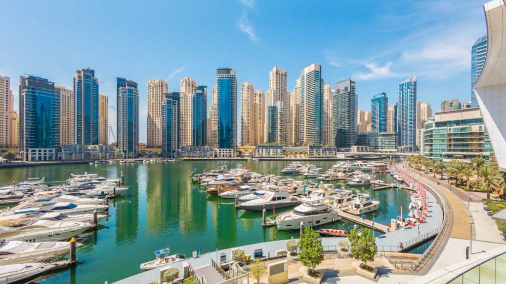 Dubai Marina di sera con grattacieli illuminati e yacht nel canale