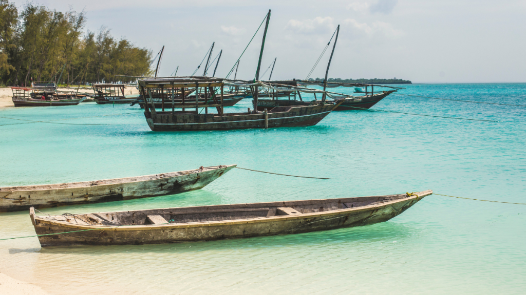 Piccola baia nel sud di Zanzibar con barche di pescatori e costa ancora selvaggia
