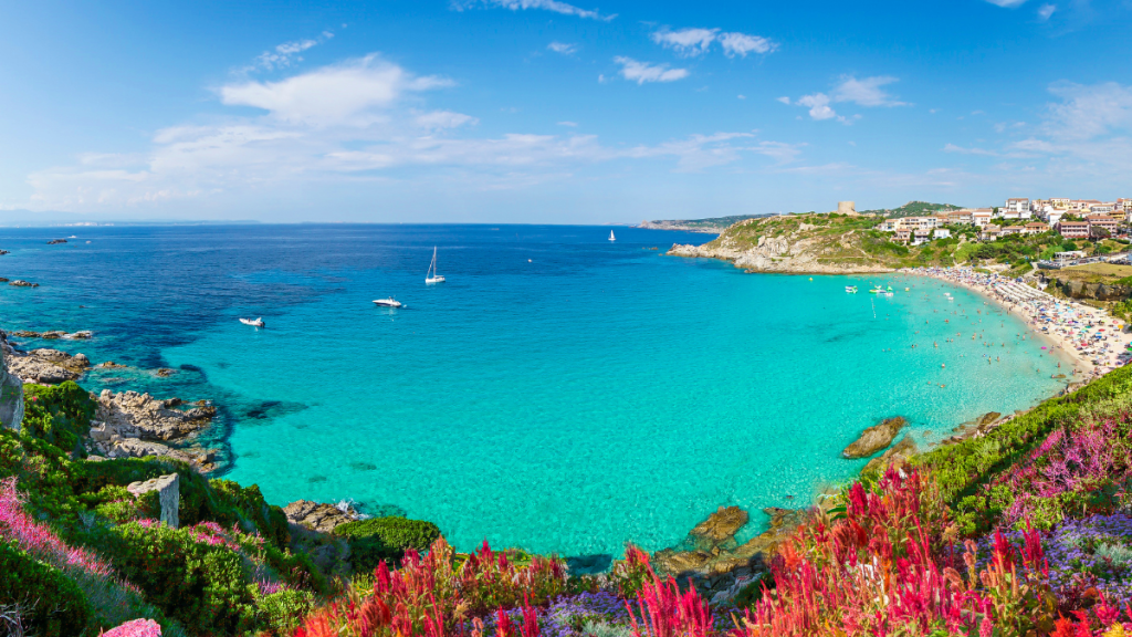 Spiaggia di mare con ombrelloni e mare azzurro in piena estate, ideale per le vacanze di agosto