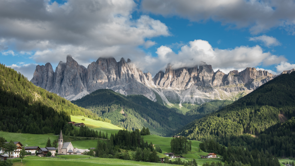 Paesaggio di montagna estiva con sentiero e vette, ideale per sfuggire al caldo di agosto
