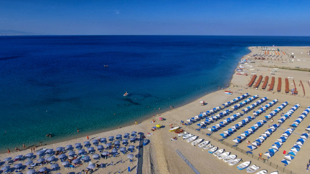 Spiaggia italiana ampia e poco affollata in agosto, perfetta per vacanze tranquille al mare